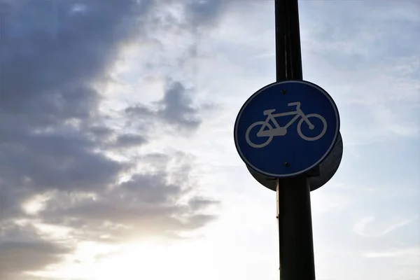 Bicycle line road sign with cloudy sky background.