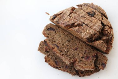 Beyaz arka planda yaban mersinli tam tahıllı ekmek. Ekmek ve ekmek kırıntıları üstte. Yukarıdan görünüşü.