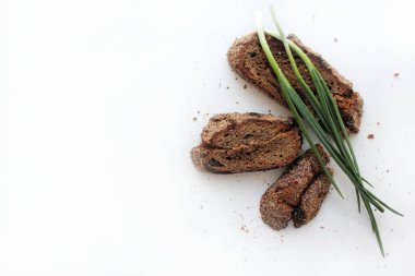 Metin için boş alan ile beyaz bir arka plan üzerinde kızılcık ve yeşil soğan tüyleri ile ev yapımı çavdar ekmeği Parçaları.