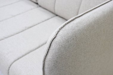 Kolçaklı gri kanepenin yakın çekim. Tekstil, yeni mobilya modern tasarım. Metin için boş alan.
