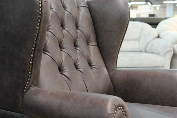 A fragment of a classic leather chair.Close-up of elegant leather texture with buttons. Fragment of a classic chair. With free space for text.
