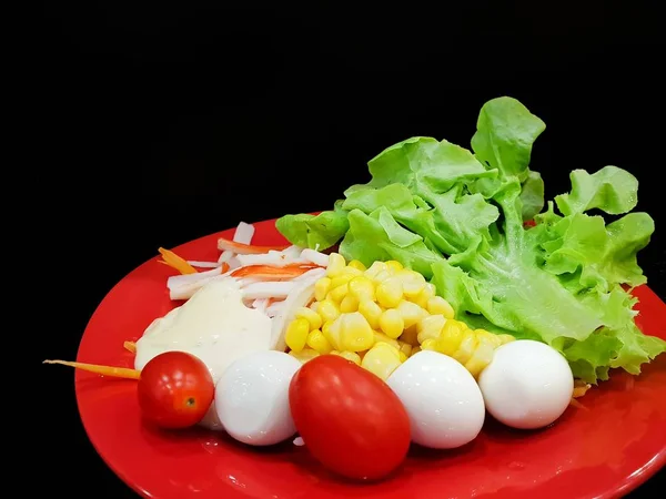 特写新鲜生菜 玉米和蛋黄酱在红盘上隔离在黑色背景 蔬菜沙拉 文本在模板的空间 健康食品的概念 — 图库照片