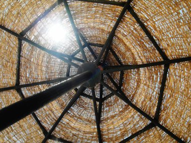 Mavi gökyüzü arka plan üzerinde hasır güneş şemsiyesi. Contre, ne yapıyorsun? Clos