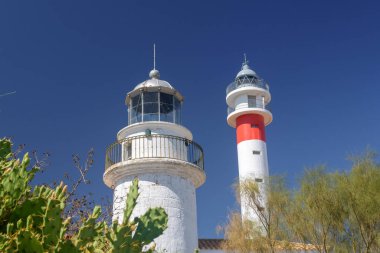 İspanya sahilinde iki deniz feneri yan yana. Eski ve modern birlikte. El Rompido, Huelva, Endülüs, İspanya 'da güneşli bir gün