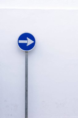 Beyaz arkaplanda mavi zorunlu yön işareti