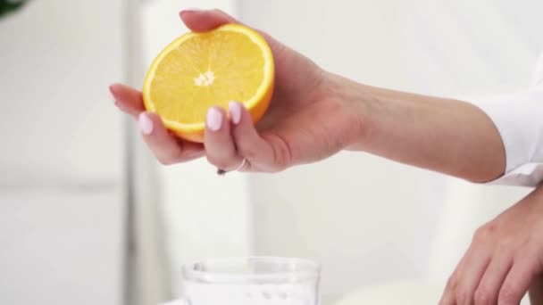 Girl Hand Squeeze Half Orange Glass Light Room Background — Stock Video