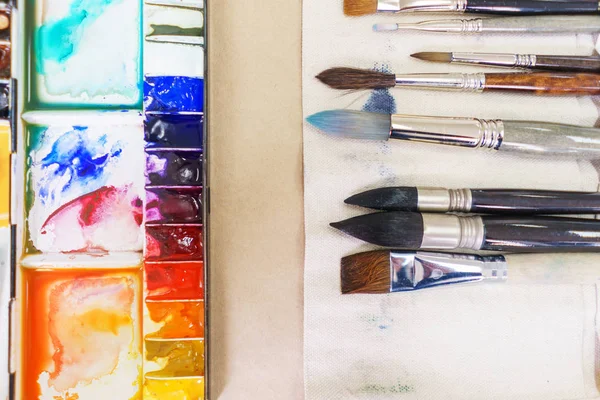 Top view of artist\'s tools while working with watercolor paint.