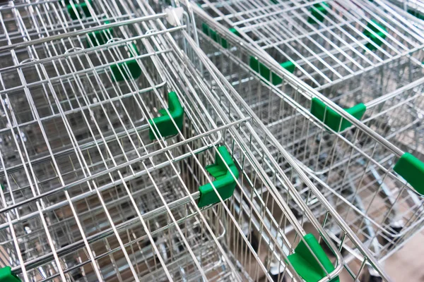 Metal baskets on wheels in a supermarket.