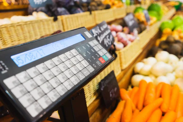 Electronic scales and control panel with a display on the counter of the vegetable market.