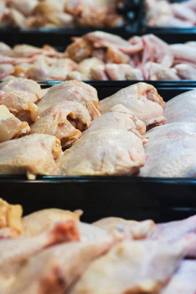 Fresh poultry meat on the counter in a showcase fridge.