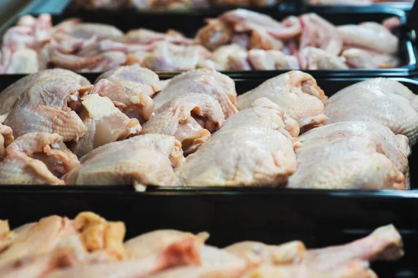 Fresh poultry meat on the counter in a showcase fridge.