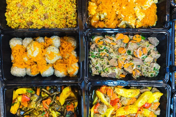 Fresh salads and light snacks on the counter in the food store.