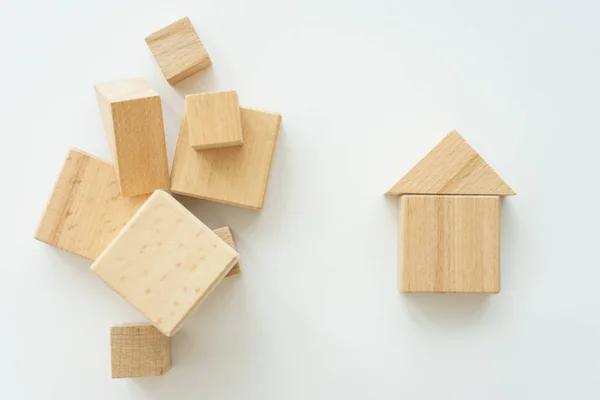 miniature small house made wooden blocks background of a stack of cubes for assembly.
