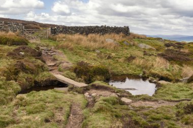 Walking on the Dales High Way between Ilkley and Addingham in West Yorkshire, showing the Swastika Stone and Ilkley Moor.  clipart