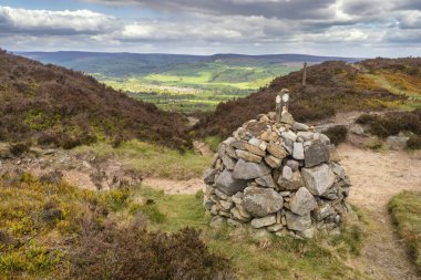 Batı Yorkshire'da İlkley ve Addingham arasındaki Dales High Way'de yürüyüş, Gamalı Haç Taşı ve İlkley Moor'u gösteriyor.. 