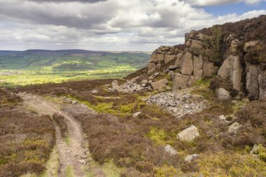 Batı Yorkshire'da İlkley ve Addingham arasındaki Dales High Way'de yürüyüş, Gamalı Haç Taşı ve İlkley Moor'u gösteriyor.. 