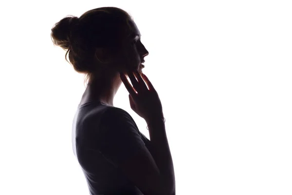 Profilo ritratto di bella ragazza con i capelli raccolti a mano, silhouette di una donna su uno sfondo bianco isolato, concetto di bellezza e moda — Foto Stock