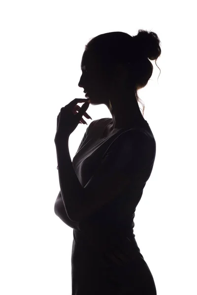 Profilo ritratto di bella ragazza con i capelli raccolti a mano, silhouette di una donna su uno sfondo bianco isolato, concetto di bellezza e moda — Foto Stock