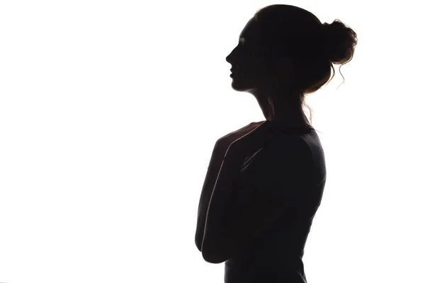 Silhouette di una giovane donna graziosa su uno sfondo bianco isolato, profilo facciale di una bella ragazza — Foto Stock