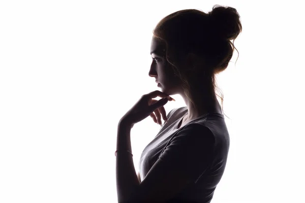 Profilo di una bella ragazza con la mano mento sprezzantemente guardando verso, fiduciosa giovane donna su uno sfondo bianco isolato — Foto Stock