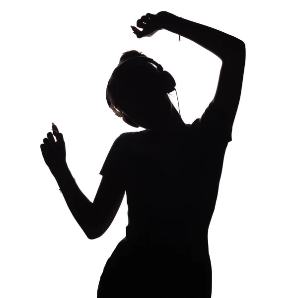 Silhouette eines Mädchens, das Musik über Kopfhörer hört, Figur einer Frau, die sich auf einem weißen, isolierten Hintergrund entspannt — Stockfoto