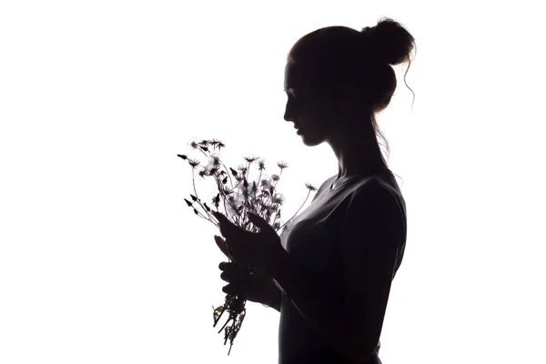 Silhouette profile of a beautiful girl with a bouquet of dried flowers on a white isolated background — Stock Photo, Image