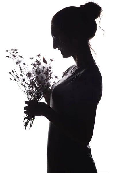 Силуэт красивой девушки с букетом сухих одуванчиков, профиль лица мечтательной молодой женщины на белом изолированном фоне — стоковое фото