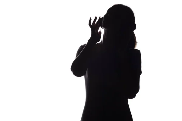 Silhouette di una ragazza che ascolta musica in cuffia su uno sfondo bianco isolato — Foto Stock