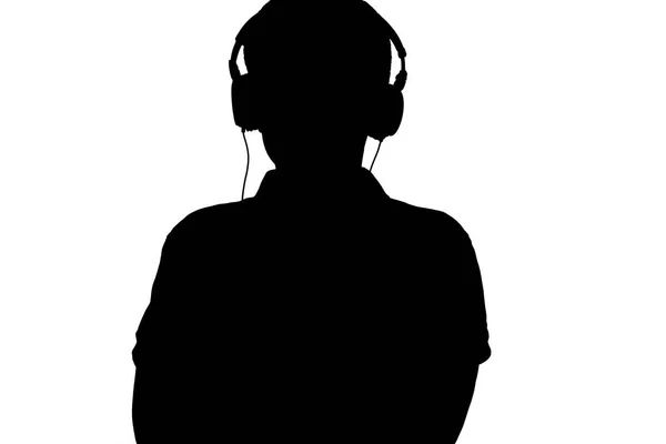 Sziluettje tinédzser hallgat zenét fejhallgató, férfi hajtogatott karját a mellkason a fehér elszigetelt háttér — Stock Fotó