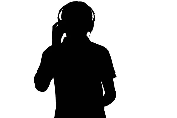 Музыкальный силуэт в наушниках на белом изолированном фоне, мальчик-подросток наслаждается любимой песней — стоковое фото