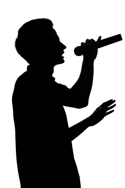 마이크로폰으로 노래하는 젊은 재능있는 남자의 실루엣 — 스톡 사진