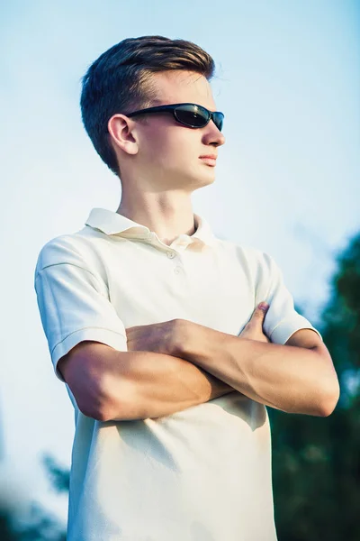 Retrato de un joven deportivo en gafas de sol, sobre la naturaleza — Foto de Stock