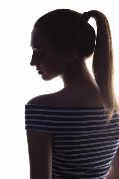 Silhouette di una ragazza adolescente su uno sfondo bianco isolato, ritratto dal retro della bella giovane donna, concetto di bellezza e moda — Foto Stock