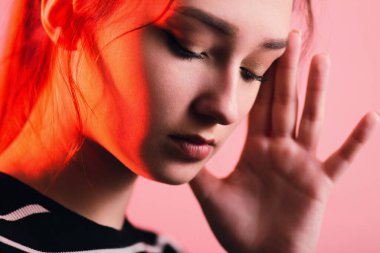 Güzel, şehvetli bir kızın portresi makyajlı ve uzun saçlı stüdyo kırmızı arka planda, konsept güzellik ve moda