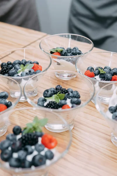 Dessert with wild berries: blackberries, blueberries, raspberries. Cream with berries at a cooking class. Cooking at home, home-made food.