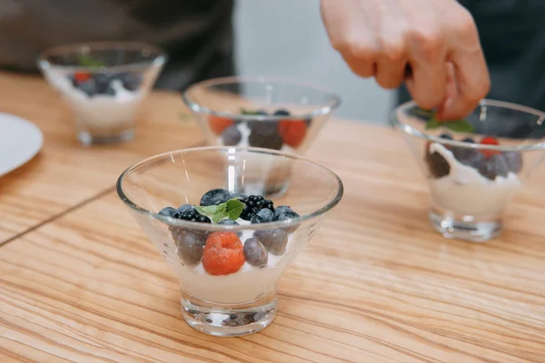 Dessert with wild berries: blackberries, blueberries, raspberries. Cream with berries at a cooking class. Cooking at home, home-made food.