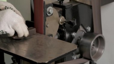 Taşlama metali. Kemer öğütme makinesi. Metal işleme. Kıvılcım. Taşlama makinesi. Öğütücüde metal öğütme. Grinder Taşlama makinesi yakın çekim. Kemer öğütme makinesi. Metal işleme makinesi. Değirmeni. Adam detayları keskinleştirir. Atölye. Kıvılcım.