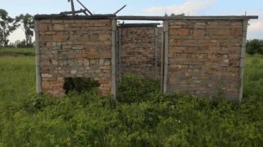 Tarlanın ortasındaki harabe ev. Terk edilmiş ev, ağaçlarla büyümüş. Kıyamet sonrası. Tuğla dansı kalıntıları. Tarlanın ortasında terk edilmiş harabe ev. Binanın kalıntıları. Çernobil. Dışlama Bölgesi. Çernobil bölgesi.