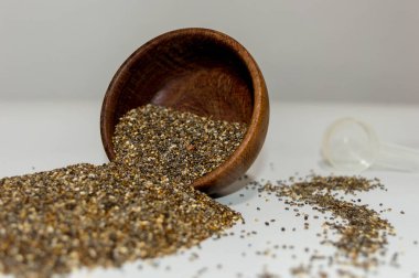 Semillas de chia en un recipiente y esparcido sobre la mesa.