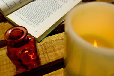 Vela, florero vacio y un libro.