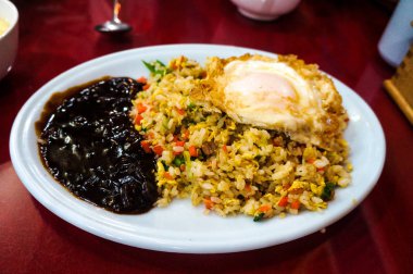 Kızarmış pilav ve siyah tabakta yumurta.