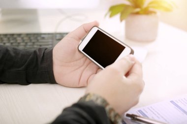 Elinde akıllı telefon tutan adamın resmi.