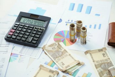 Tabloda hesap makinesi, grafik kağıt ve Hint 10 rupi para notları Resmi.