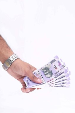 Elinde 100 rupilik Hint notları. Beyaz arka planda yalıtılmış.