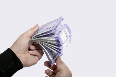 Elinde 100 rupilik Hint notları. Beyaz arka planda yalıtılmış.