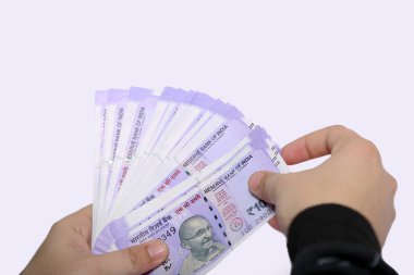 Adam eli Hint 100 rupi para tutuyor. Beyaz arka planda yalıtılmış.