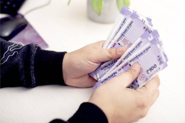 Yeni Hint para birimi banknotları ile el. Beyaz arka planda yalıtılmış.