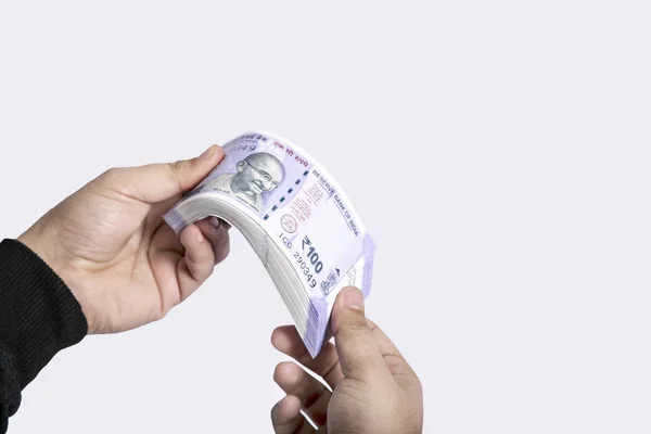 手的图片是持有印度100卢比的货币 在白色背景上隔离 — 图库照片
