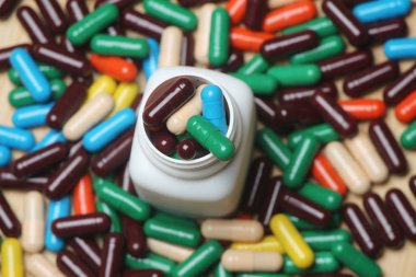 Ahşap arka plan üzerinde beyaz şişe ile Ayurveda vitamin kapsülü Closeup.