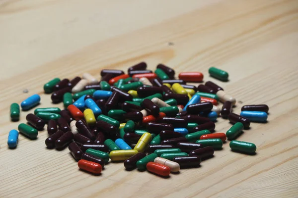 Close up of Ayurvedic colorful capsule on wooden table.